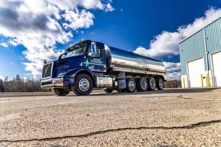 Navy Water Transport tanker with a stainless steel tank parked in the yard