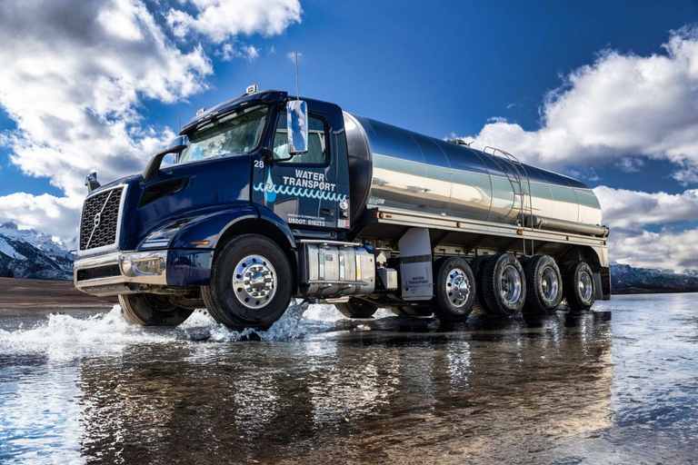 Water Transport stainless steel tanker driving through a wide splash of water