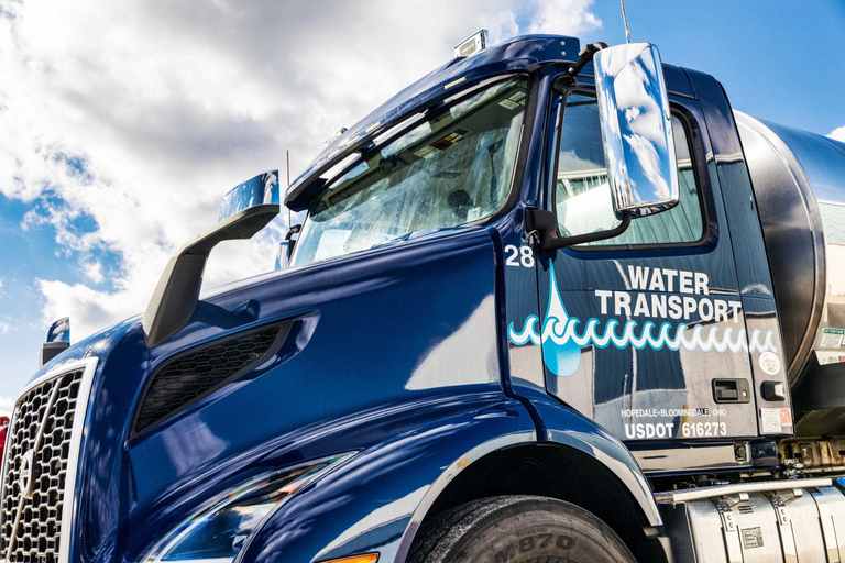 Close view of a navy Water Transport tanker cab showing the USDOT number on the door